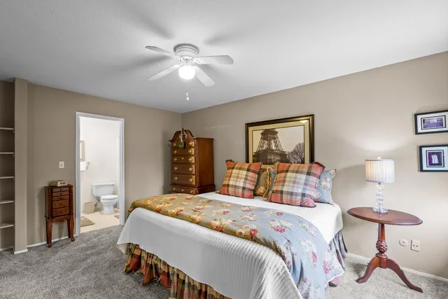 a spacious bedroom with a bed and ceiling fan