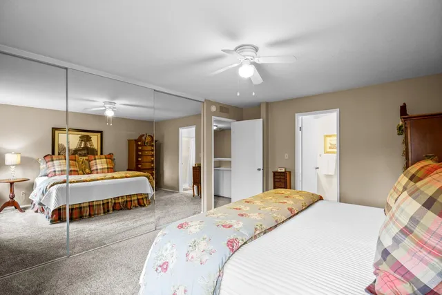 a spacious bedroom with a large bed and a chandelier