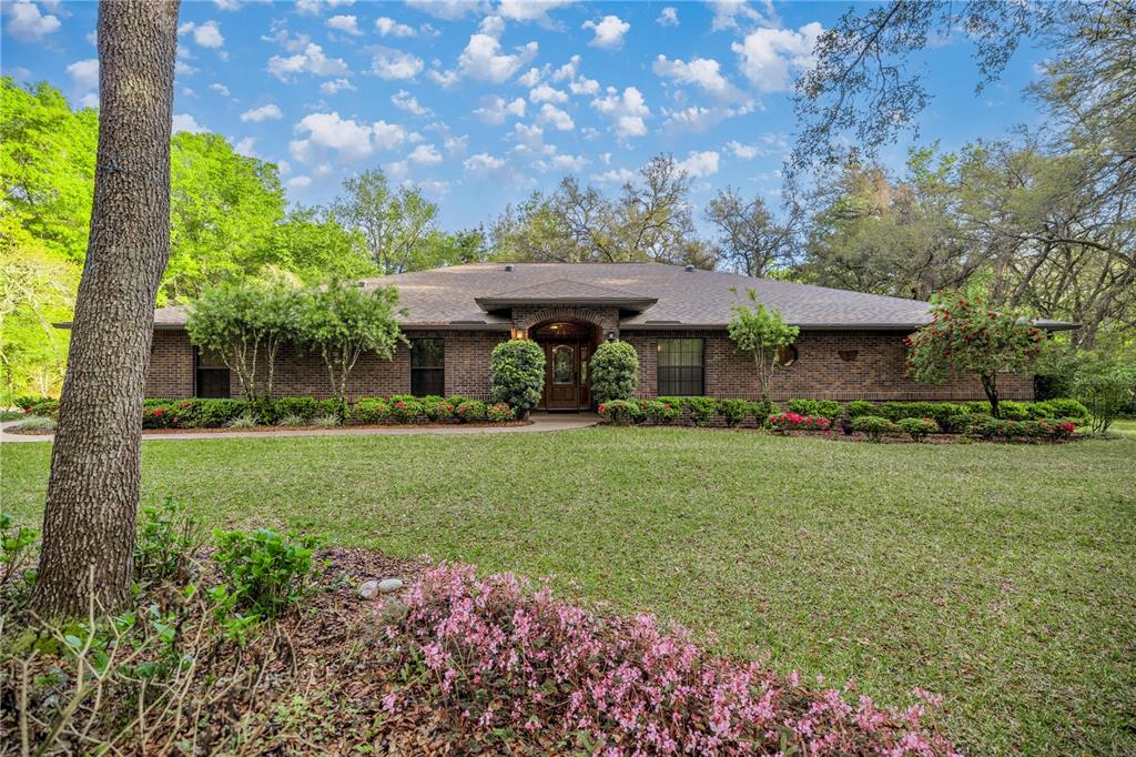 5889 Northeast 43rd Lane Road Silver Springs, FL 34488 - Photo 1 of 1 a front view of a house with garden