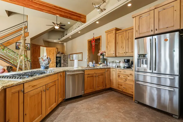 a kitchen with granite countertop a sink stainless steel appliances and cabinets