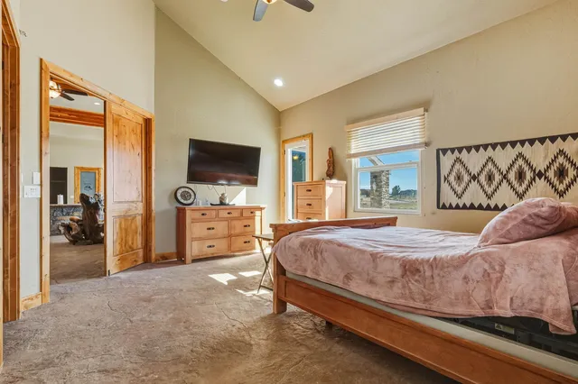 a bedroom with a bed and a flat tv screen on wall