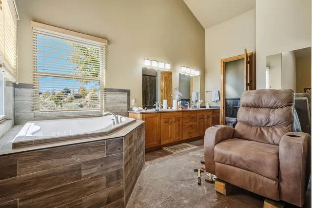 a bathroom with a double vanity sink mirror and a bathtub