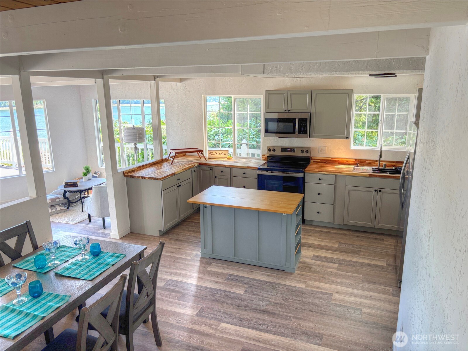 81 East Panorama Way Grapeview, WA 98546 - Photo 11 of 21 a kitchen with stainless steel appliances granite countertop a stove top oven a sink dishwasher a dining table and chairs with wooden floor