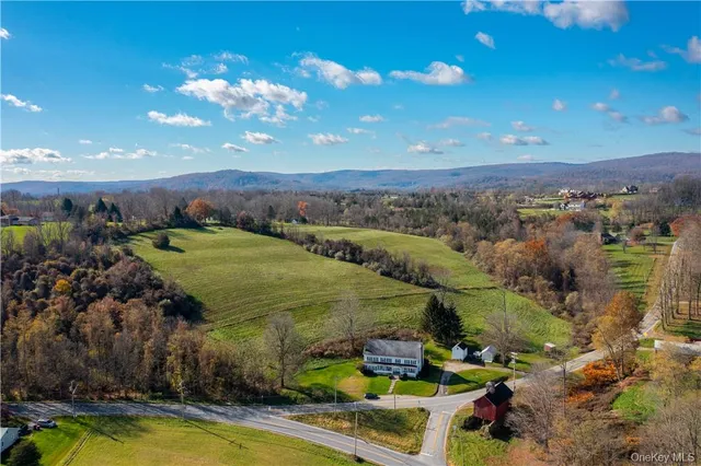 a view of a city with lots of trees and houses with swimming pool