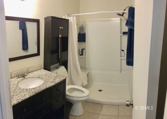 509 South Helena Street Ridgecrest, CA 93555 - Photo 20 of 40 a bathroom with a granite countertop shower a sink and toilet