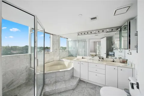 a bathroom with a granite countertop sink mirror and bathtub