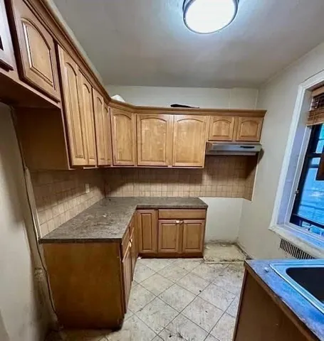 a kitchen with granite countertop a sink a stove and cabinets