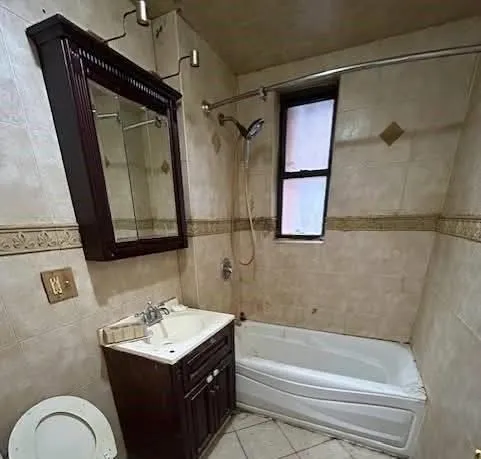 a bathroom with a bathtub shower sink vanity and mirror