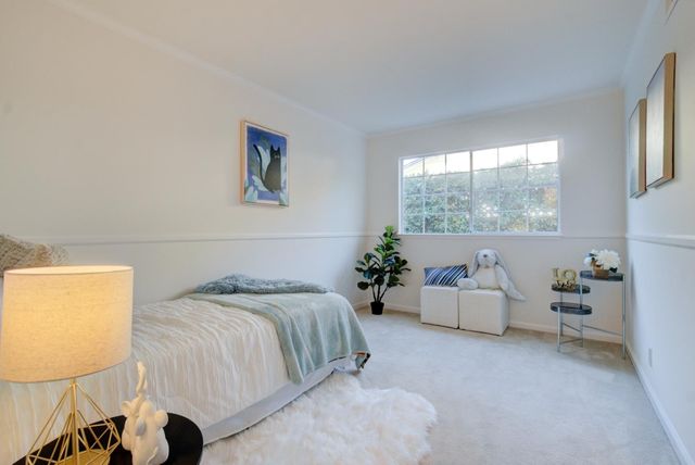 a bed sitting in a bedroom next to a window