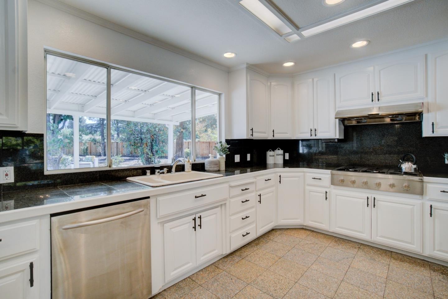 18444 Purdue Drive Saratoga, CA 95070 - Photo 10 of 31 a kitchen with stainless steel appliances granite countertop a stove a sink and white cabinets