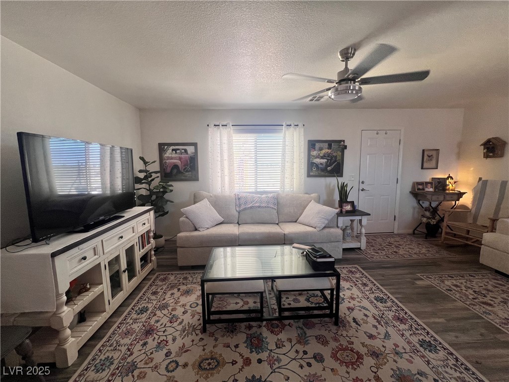 2970 Rio Rico Drive Pahrump, NV 89048 - Photo 15 of 53 Living area with a textured ceiling, a ceiling fan, and wood finished floors