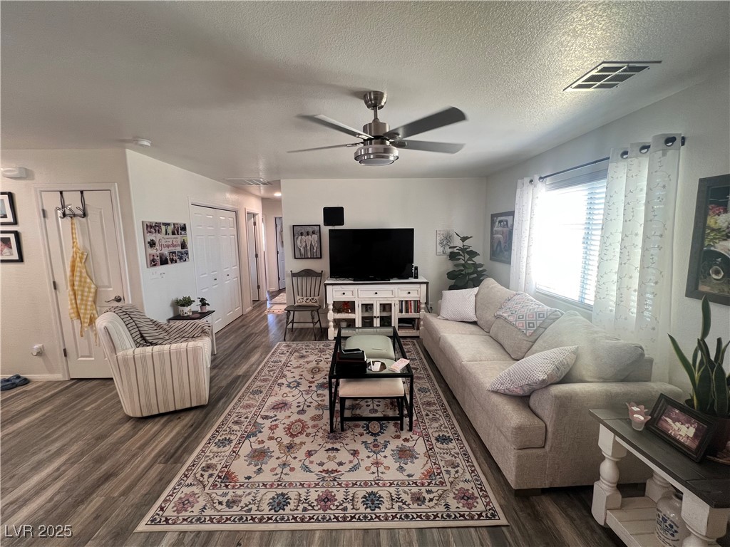 2970 Rio Rico Drive Pahrump, NV 89048 - Photo 16 of 53 Living room featuring a ceiling fan, a textured ceiling, and dark wood-style flooring