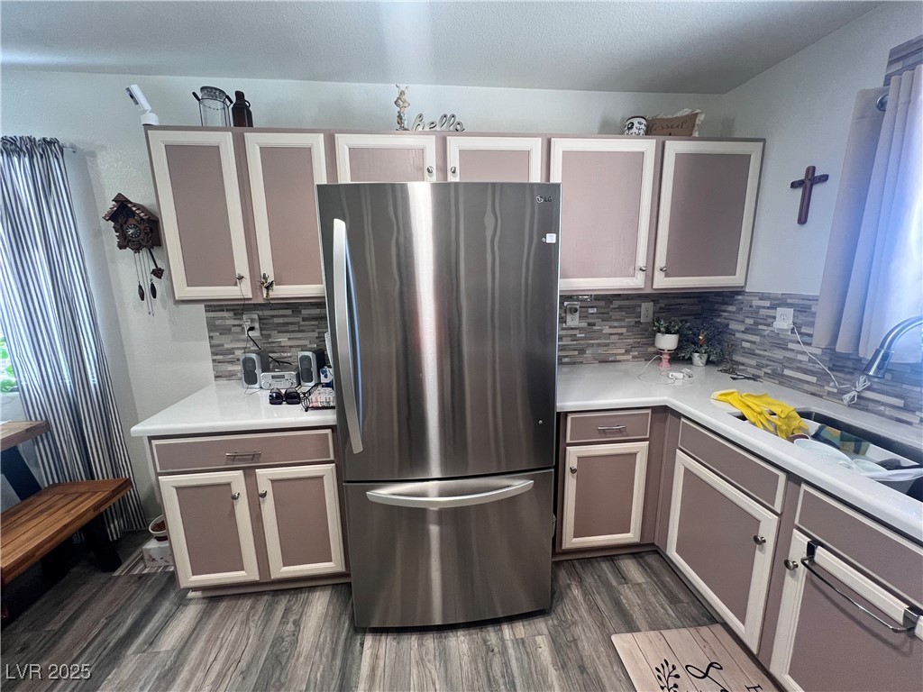 2970 Rio Rico Drive Pahrump, NV 89048 - Photo 21 of 53 Kitchen featuring freestanding refrigerator, light countertops, tasteful backsplash, and dark wood-style flooring