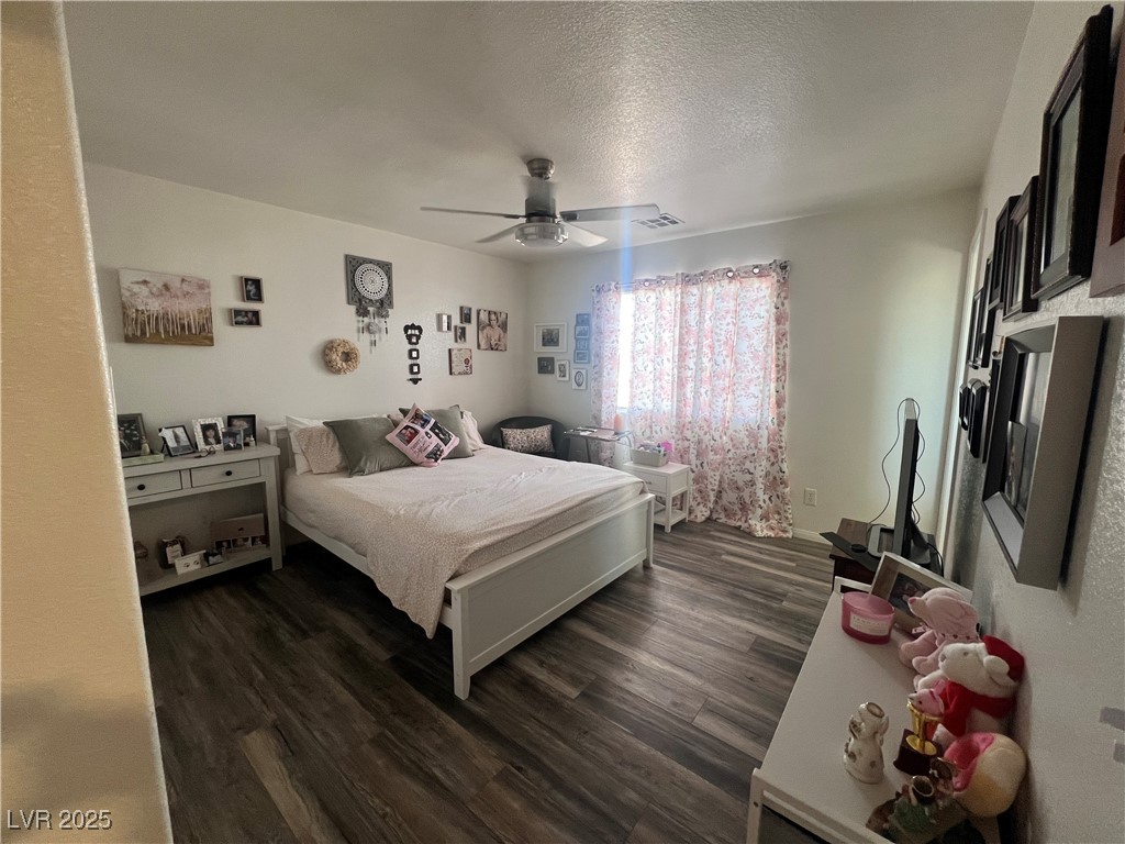 2970 Rio Rico Drive Pahrump, NV 89048 - Photo 27 of 53 Primary Bedroom featuring dark wood finished floors, a textured ceiling, and ceiling fan