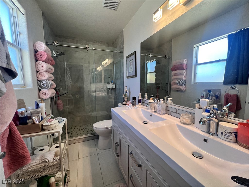 2970 Rio Rico Drive Pahrump, NV 89048 - Photo 31 of 53 Bathroom featuring a shower stall, double vanity, and tile patterned floors