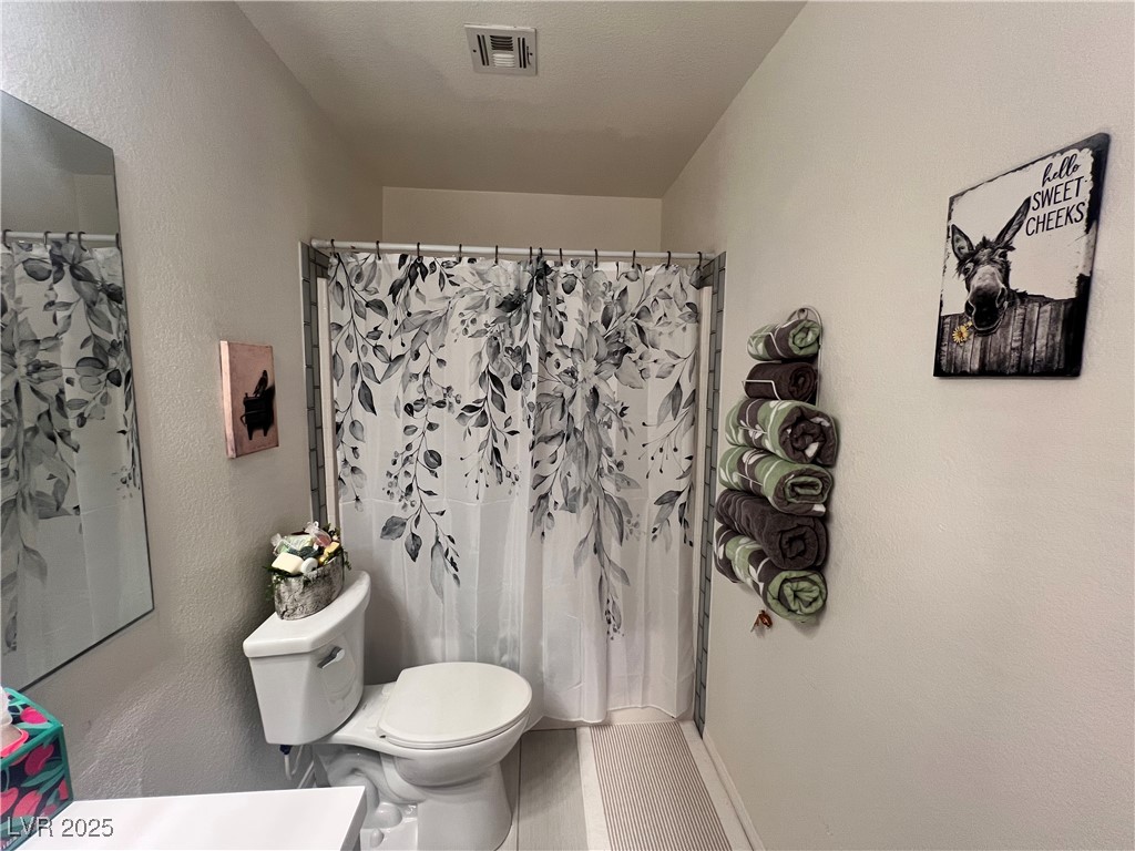 2970 Rio Rico Drive Pahrump, NV 89048 - Photo 36 of 53 Full bath with vanity, a shower with curtain, and a textured wall