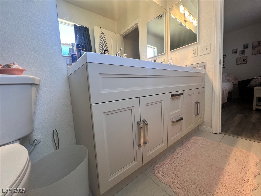 2970 Rio Rico Drive Pahrump, NV 89048 - Photo 37 of 53 Bathroom with a textured wall, connected bathroom, vanity, and tile patterned flooring