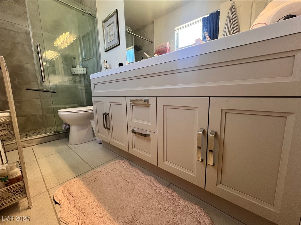 2970 Rio Rico Drive Pahrump, NV 89048 - Photo 40 of 53 Bathroom with a stall shower, tile patterned floors, and vanity