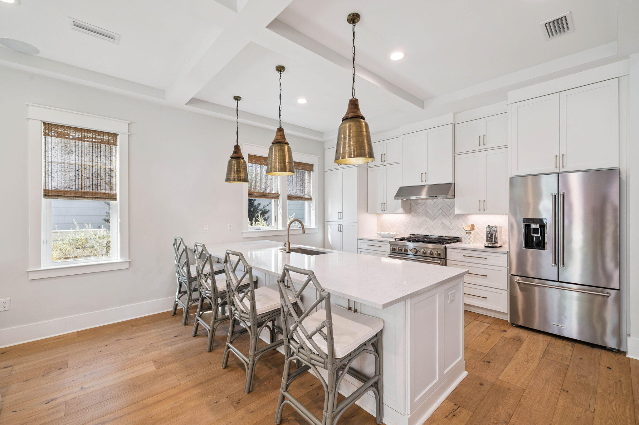 64 White Cottage Road Santa Rosa Beach, FL 32459 - Photo 11 of 35 a kitchen with stainless steel appliances kitchen island granite countertop a refrigerator a stove a sink dishwasher a dining table and chairs with wooden floor