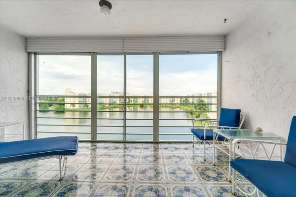 a living room with furniture and floor to ceiling window