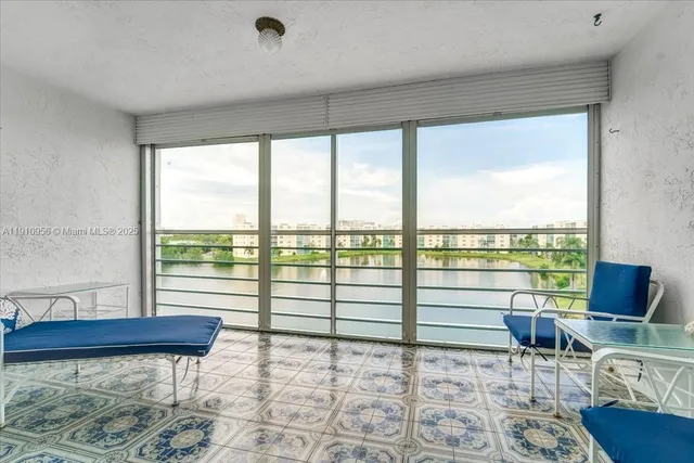 a living room with furniture and a floor to ceiling window