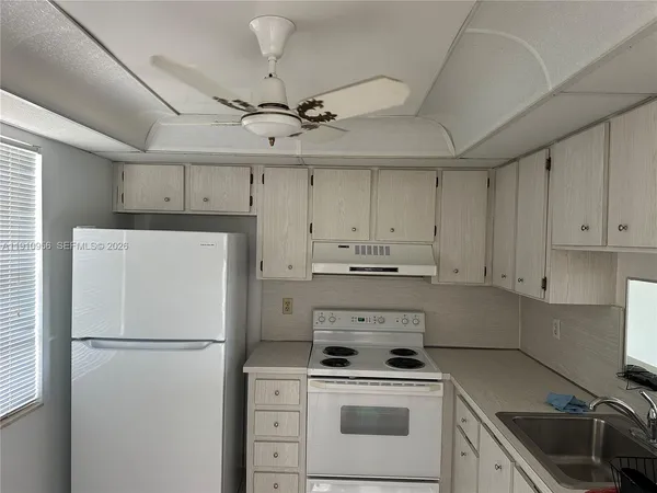 a white refrigerator freezer and a stove in a kitchen