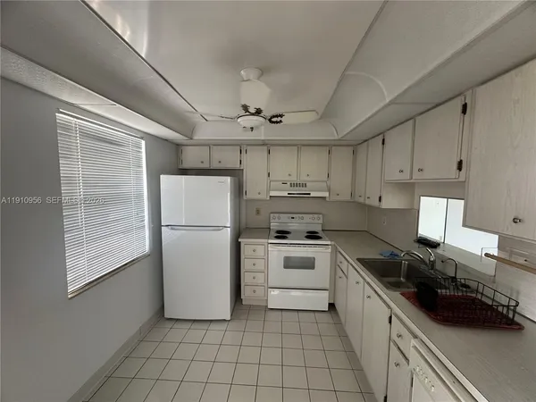 a kitchen with a refrigerator a stove a sink and cabinets