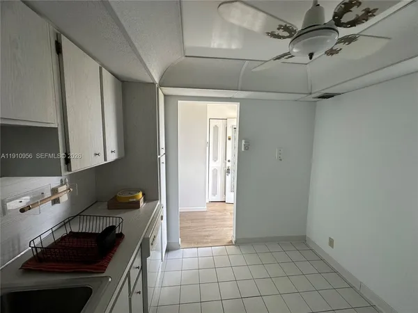 a kitchen with white cabinets and appliances