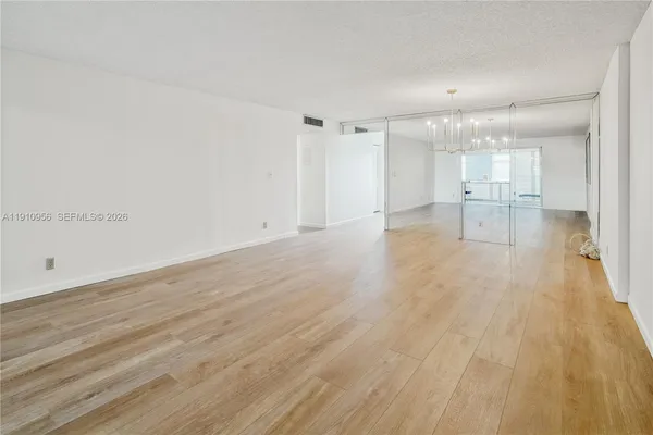 a view of empty room with wooden floor