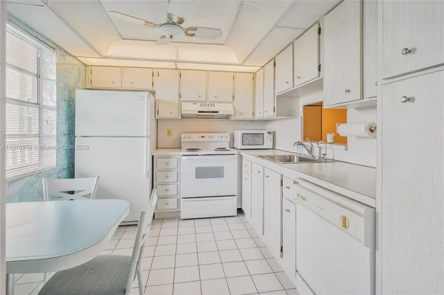 a kitchen with white cabinets and white appliances