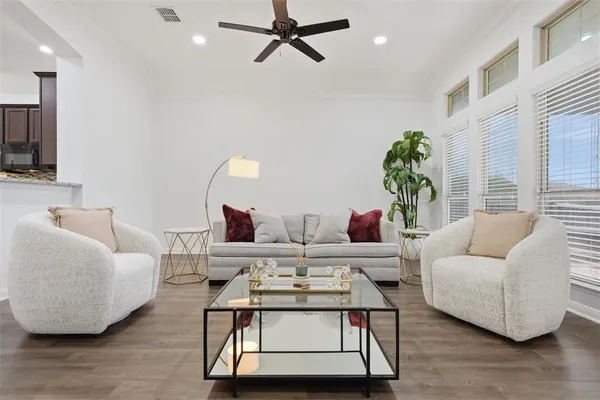 a living room with furniture and a wooden floor