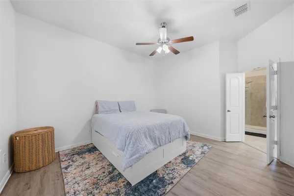 a bedroom with a bed and wooden floor