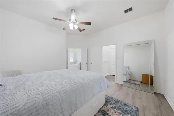 a spacious bedroom with a bed and a chandelier