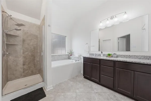 a bathroom with a tub a sink and mirror