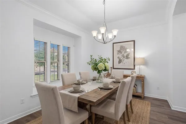 a view of a dining room with furniture a chandelier and wooden floor