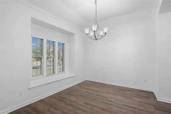 a view of empty room with wooden floor and window