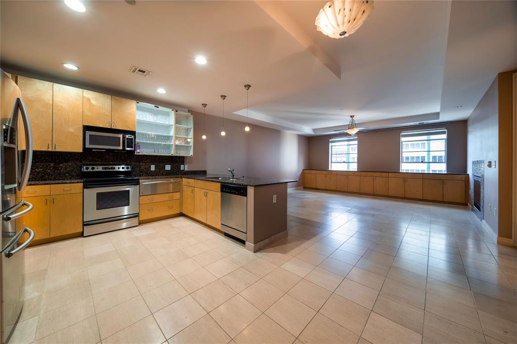 a large kitchen with stainless steel appliances kitchen island granite countertop a large stove top oven and cabinets