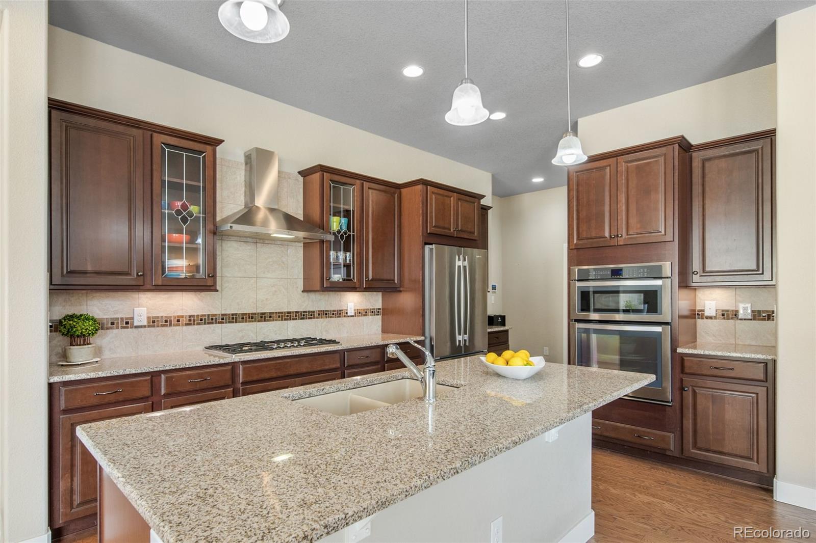 17670 West 94th Drive Arvada, CO 80007 - Photo 12 of 49 a kitchen with stainless steel appliances granite countertop a sink refrigerator and stove
