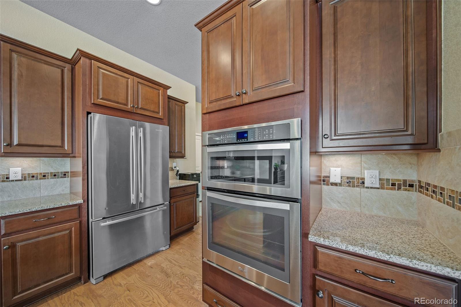 17670 West 94th Drive Arvada, CO 80007 - Photo 14 of 49 a kitchen with granite countertop stainless steel appliances and cabinets