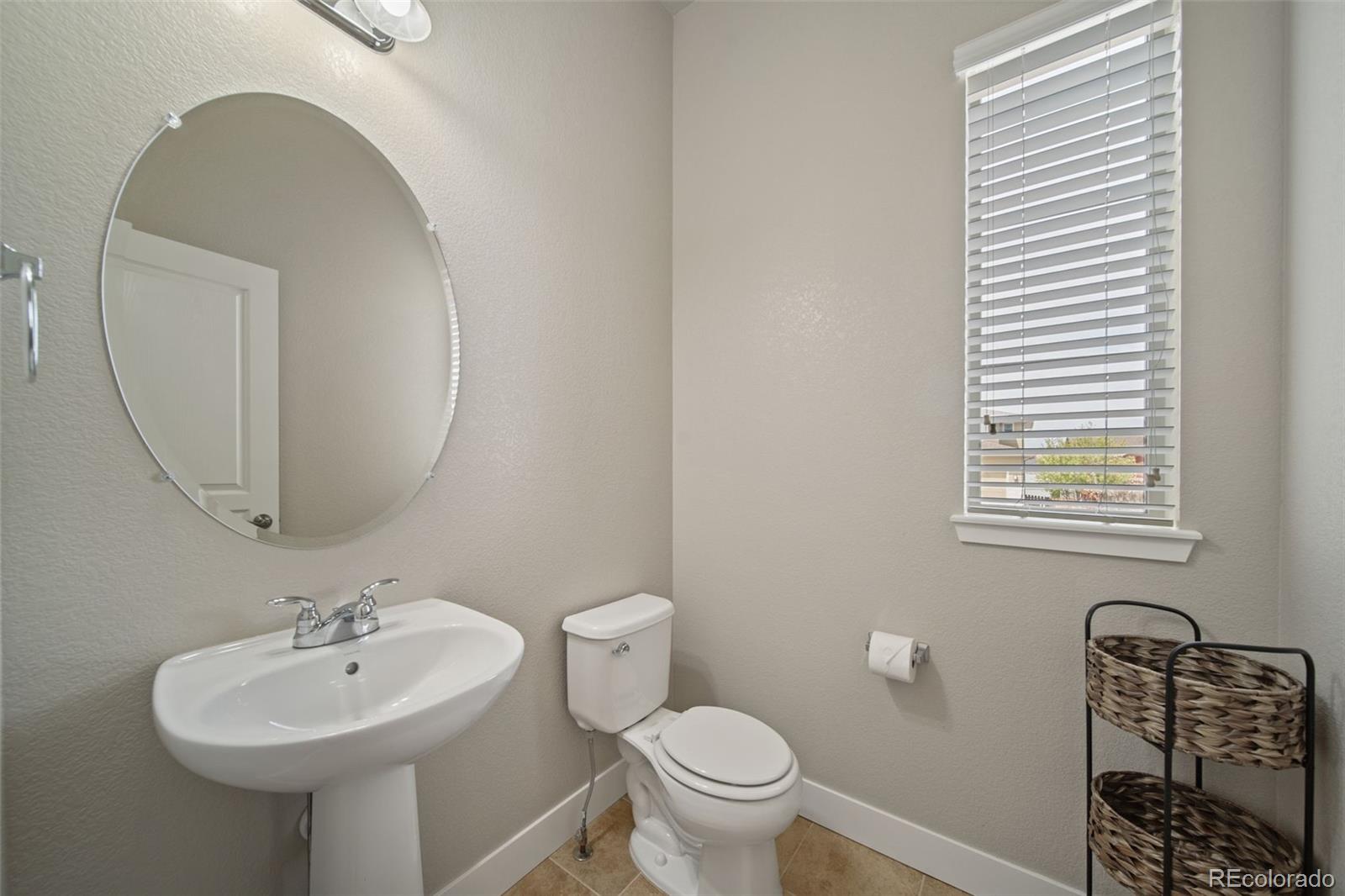 17670 West 94th Drive Arvada, CO 80007 - Photo 19 of 49 a bathroom with a sink a mirror a toilet and a window