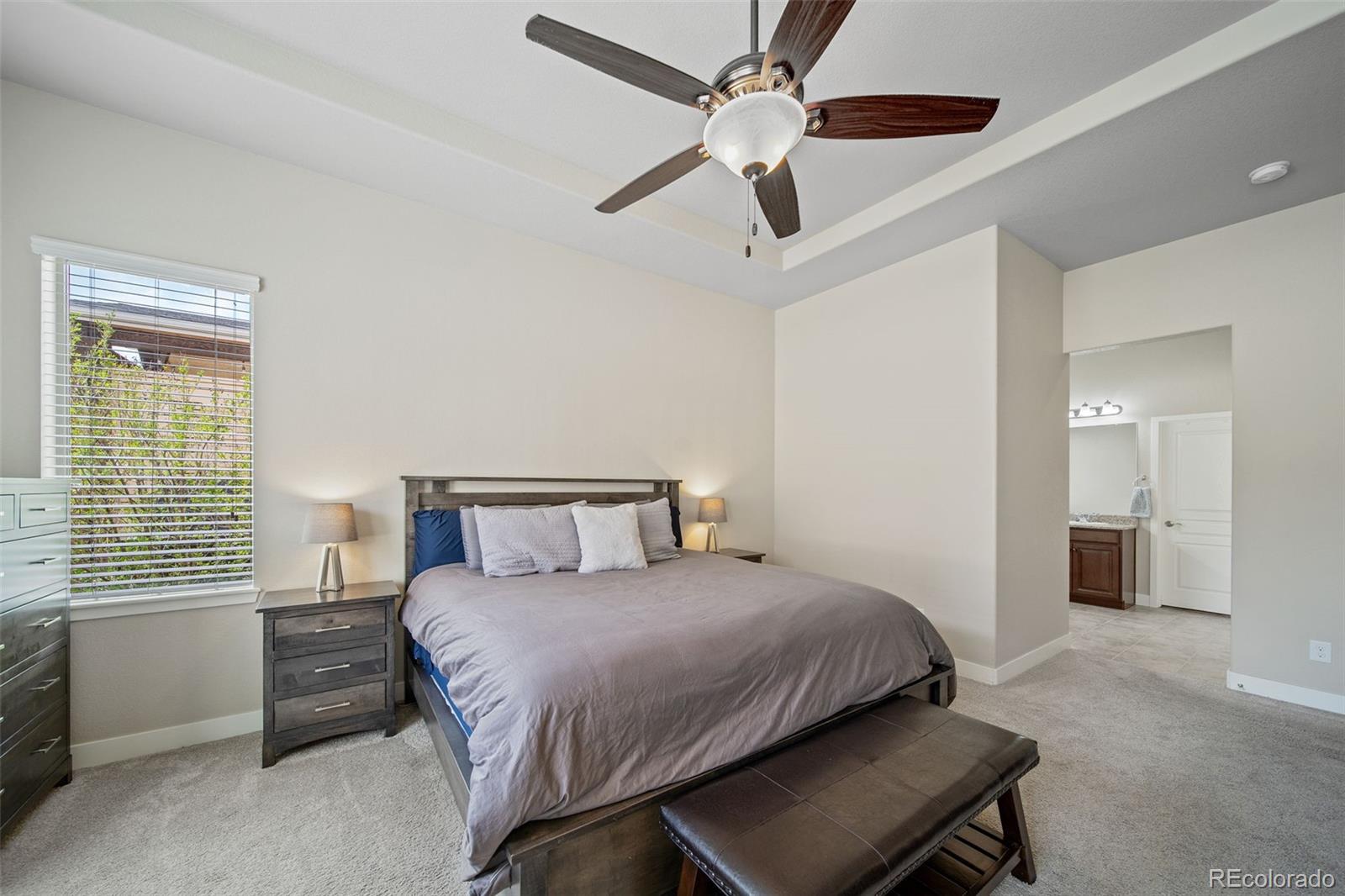 17670 West 94th Drive Arvada, CO 80007 - Photo 21 of 49 a bedroom with a bed and a chandelier