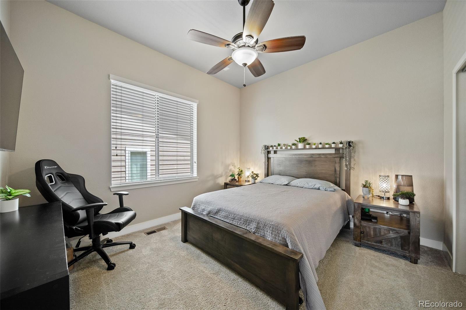 17670 West 94th Drive Arvada, CO 80007 - Photo 30 of 49 a bedroom with a bed a chair and a chandelier