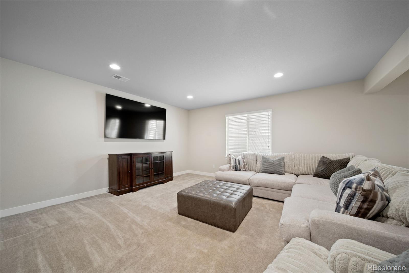 17670 West 94th Drive Arvada, CO 80007 - Photo 33 of 49 a living room with furniture and a flat screen tv
