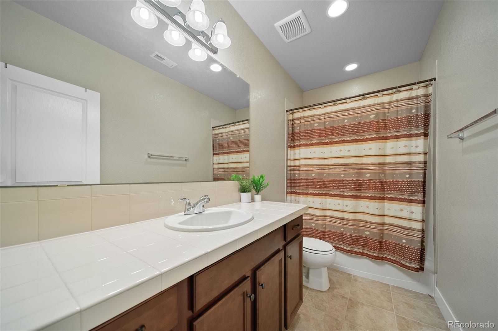 17670 West 94th Drive Arvada, CO 80007 - Photo 39 of 49 a bathroom with a sink a toilet and a mirror