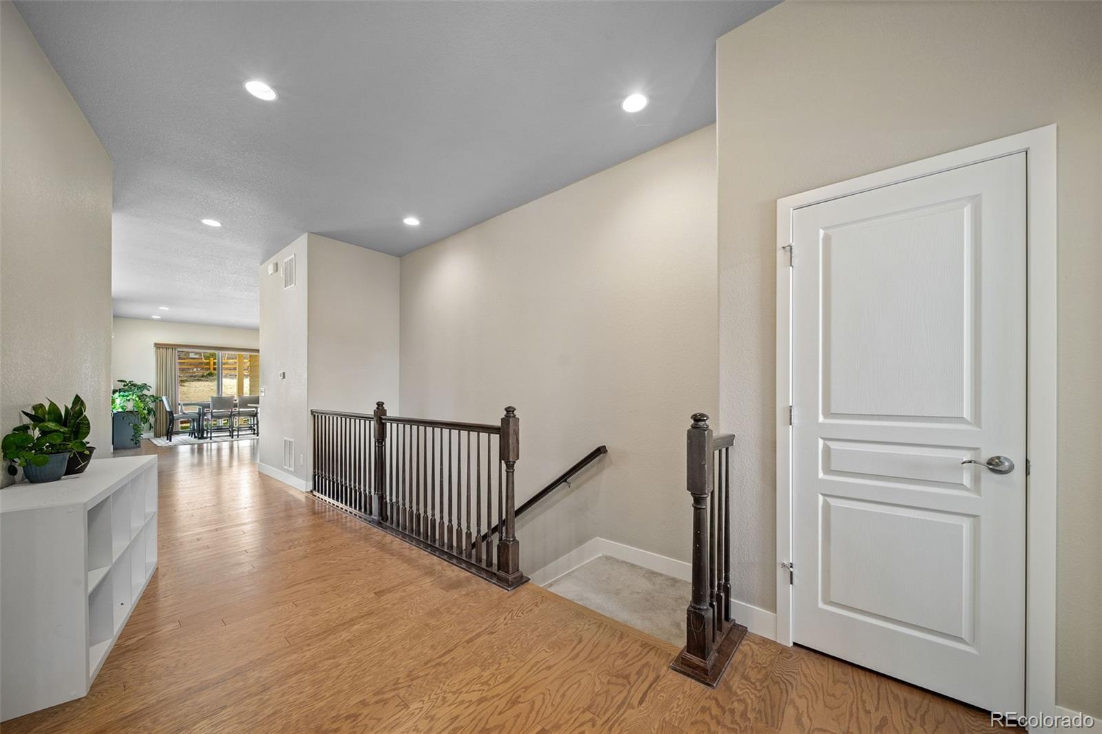 17670 West 94th Drive Arvada, CO 80007 - Photo 6 of 49 a view of hallway with dining room and wooden floor