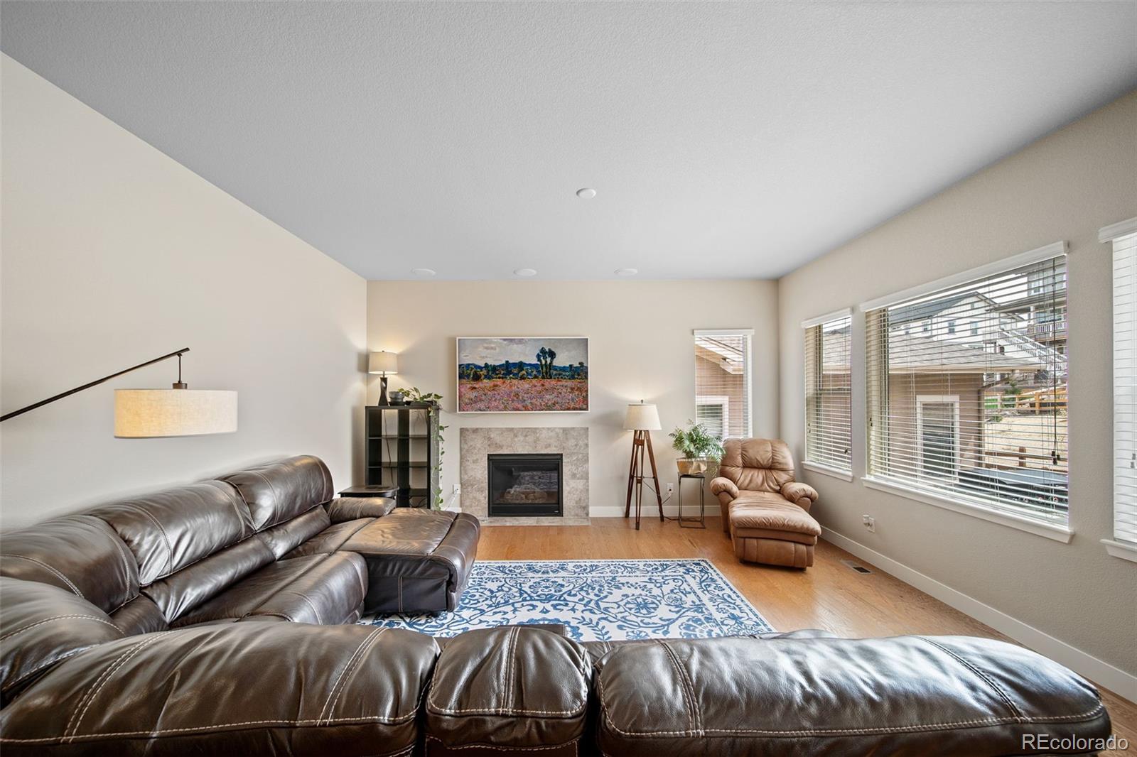 17670 West 94th Drive Arvada, CO 80007 - Photo 8 of 49 a living room with furniture and a fireplace