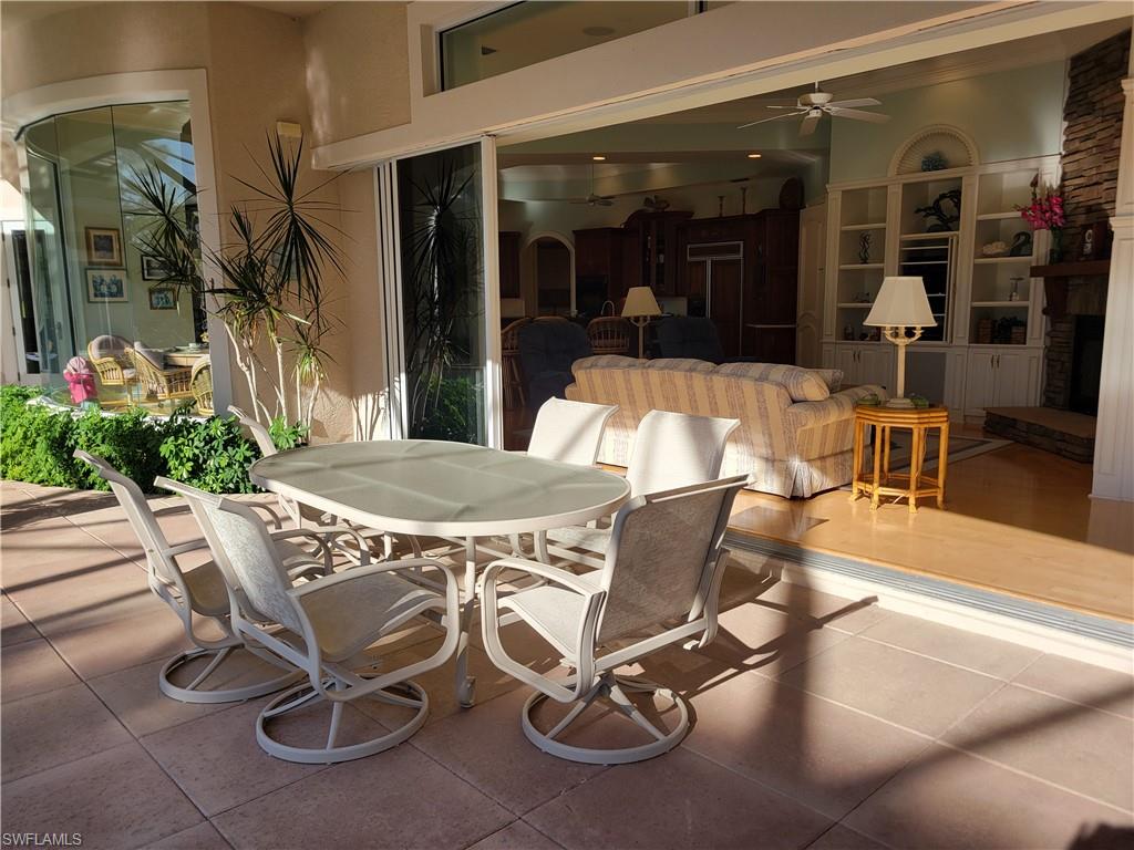 1269 Pocantico Lane Naples, FL 34110 - Photo 24 of 45 a view of a patio with table and chairs and potted plants
