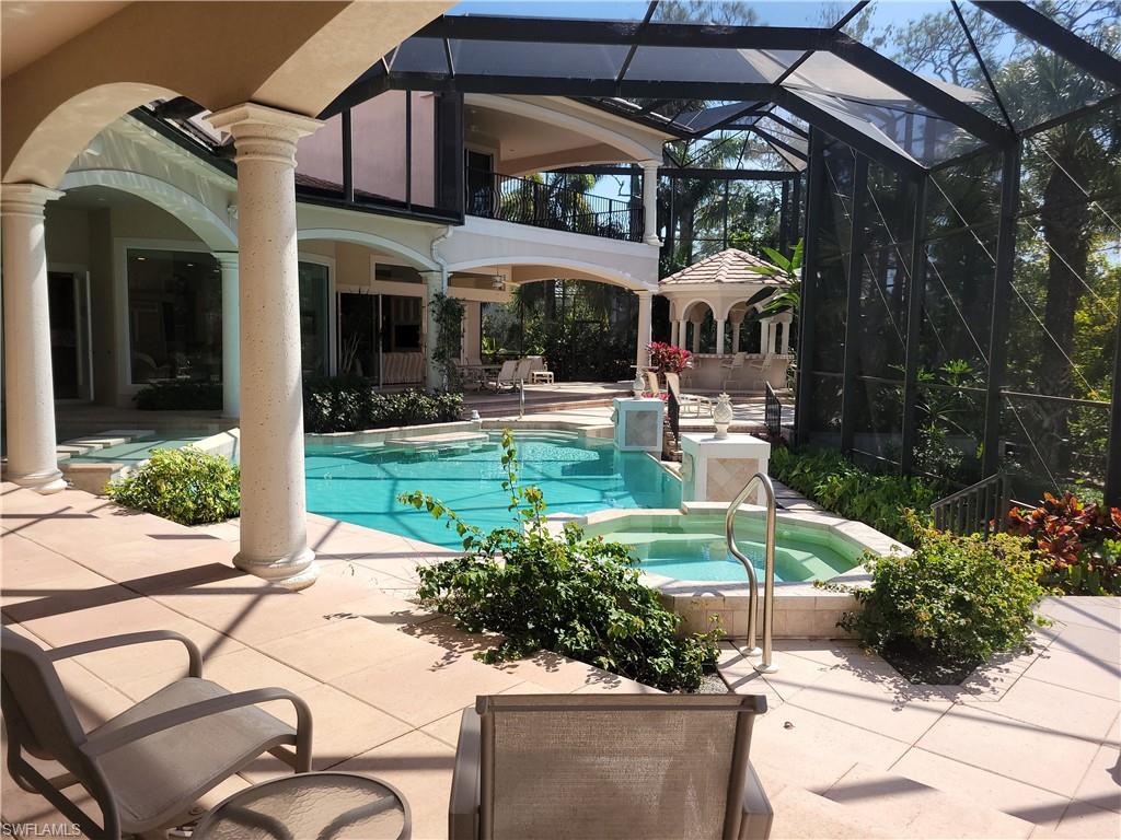 1269 Pocantico Lane Naples, FL 34110 - Photo 43 of 45 a view of a patio with table and chairs under an umbrella