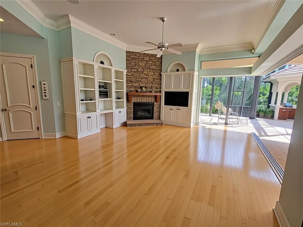 1269 Pocantico Lane Naples, FL 34110 - Photo 8 of 45 a view of a livingroom with furniture wooden floor fireplace and windows