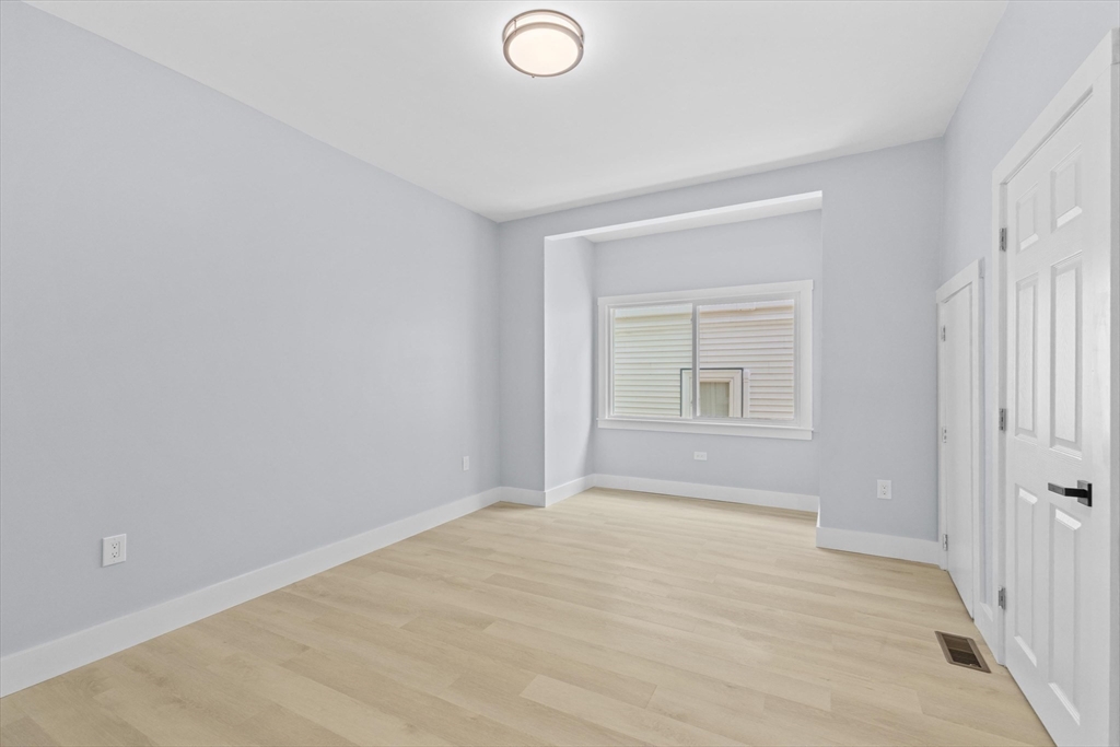 15 Bennett Street Everett, MA 02149 - Photo 29 of 39 a view of an empty room with wooden floor and a window